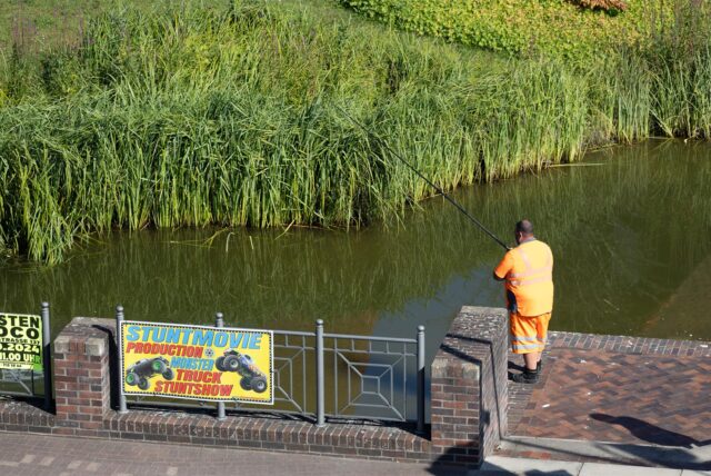 Ein Angler an der Wall- und Grabenanlage