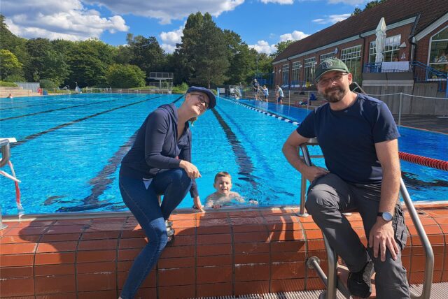 Richard Feuerstein im 50-Meter-Becken im Freibad des Copa Ca Backum, am Beckenrand seine Eltern.