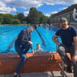 Richard Feuerstein im 50-Meter-Becken im Freibad des Copa Ca Backum, am Beckenrand seine Eltern.