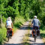 Zwei Radfahrer auf einem Feldweg.