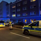 Polizeiwagen stehen vor einem Haus.