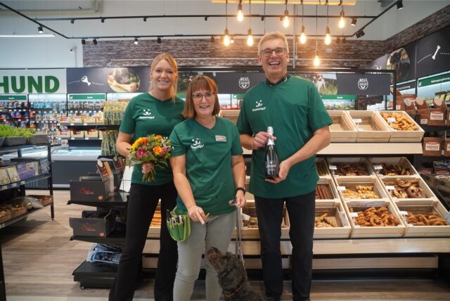 Julia Schlotmann-Honsel, Monika Boullier und Ralf Honsel stehen im neuen Fressnapf Geschäft mit einem Hund.