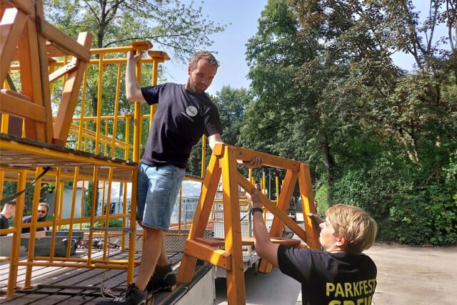 Zwei Männer heben Aufbauten von einem Lkw.