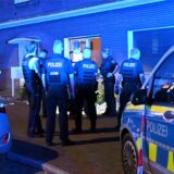 Polizisten stehen vor dem Mehrfamilienhaus am Ostwall.