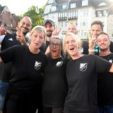 Ein Team bei der Castropiade, gekleidet in schwarzen T-Shirts, jubelt.