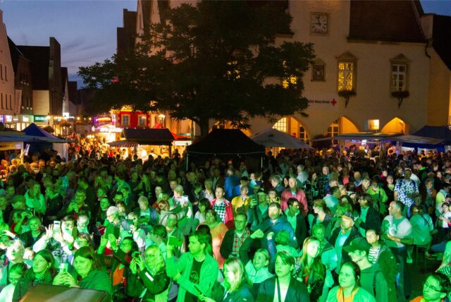 Menschen klatschen und tanzen auf dem Markt.