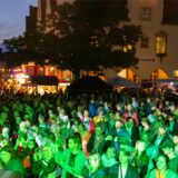 Menschen klatschen und tanzen auf dem Markt.