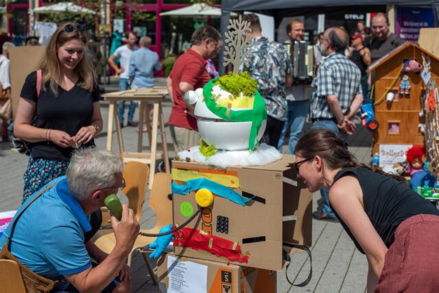 Menschen testen beim Tomorrathon in Gießen 2022 auf einer Straße Angebote.
