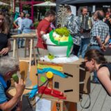 Menschen testen beim Tomorrathon in Gießen 2022 auf einer Straße Angebote.