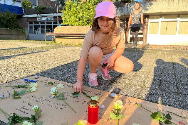 Die neunjährige Amneh legte bei der Mahnwache auf dem Lambertusplatz eine Rose und Teelichter nieder.