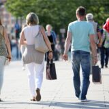Passanten mit Einkaufstüten laufen durch die Innenstadt.