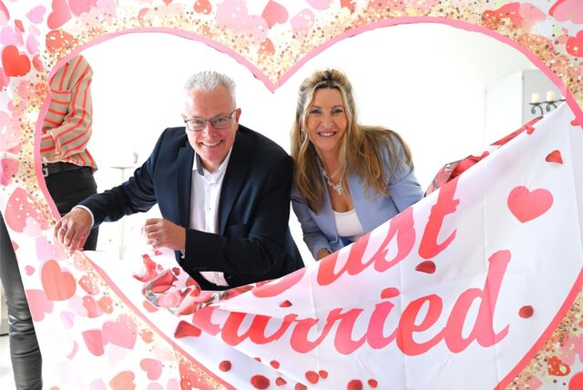 Susanne und Uwe Silvers mit einem Banner nach ihrer Hochzeit.