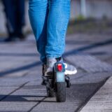 Eine Person fährt mit seinem E-Scooter über den Bahnsteig.