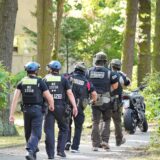 Polizisten eines Spezialeinsatzkommandos (SEK) gehen zu einem Mehrfamilienhaus in Berlin.