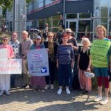 Menschen mit Plakaten an den Körpern.
