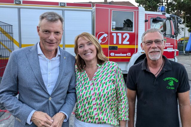 Bürgermeister Tesche, eine Frau und ein Mann lächeln in die Kamera. Hinter ihnen steht ein Feuerwehrwagen.