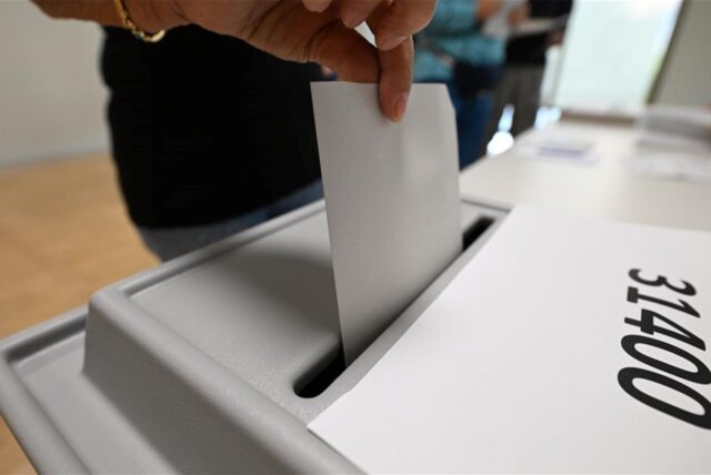 Eine Frau wirft bei der Stimmabgabe zur Landtagswahl in Sachsen in einem Wahllokal ihren Stimmzettel in die Wahlurne.