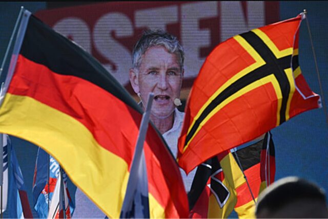 Björn Höcke, AfD-Spitzenkandidat in Thüringen, ist während einer Demonstration der AfD als Wahlkampfabschluss auf dem Domplatz hinter Fahnen auf einer Videoleinwand zu sehen.
