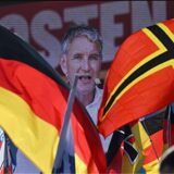 Björn Höcke, AfD-Spitzenkandidat in Thüringen, ist während einer Demonstration der AfD als Wahlkampfabschluss auf dem Domplatz hinter Fahnen auf einer Videoleinwand zu sehen.