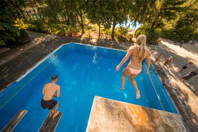Zwei Badegäste springen von den Sprungtürmen im Freibad Wischlingen.