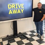 Annkatrin und Dennis Haak stehen in ihrer neuen Fahrschule „Drive Away“ in Dorsten neben einem Smartboard.