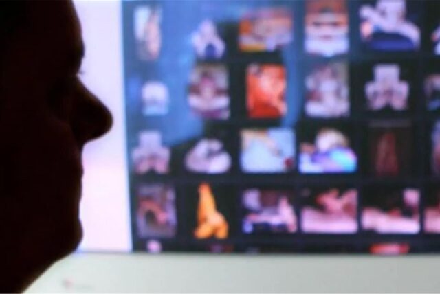 Ein Mann schaut auf einem Bildschirm pornografische Inhalte an