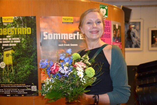 Ausstatterin Anja Müller hält einen Blumenstrauß in der Hand.