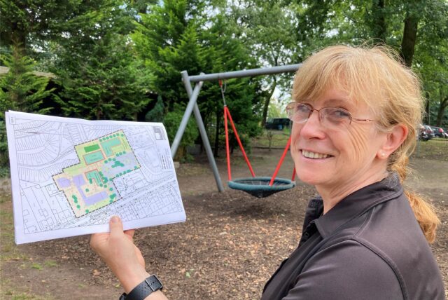 Schulleiterin Susanne Nastula steht mit den Plänen für die Turnhalle und den Anbau auf dem Schulhof der Glück-auf-Schule in Brassert.