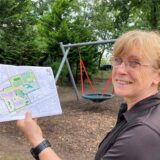 Schulleiterin Susanne Nastula steht mit den Plänen für die Turnhalle und den Anbau auf dem Schulhof der Glück-auf-Schule in Brassert.