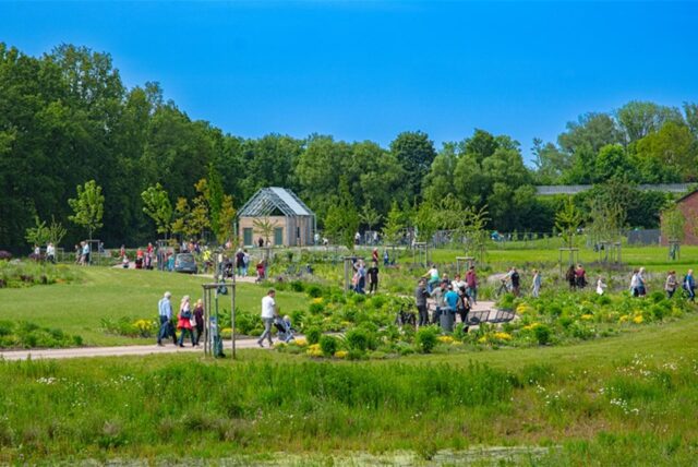 Im Natur- und Wasser-Erlebnis-Parks laufen Menschen über die Wege.