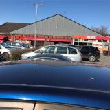 Autos parken auf einem Supermarktparkplatz.