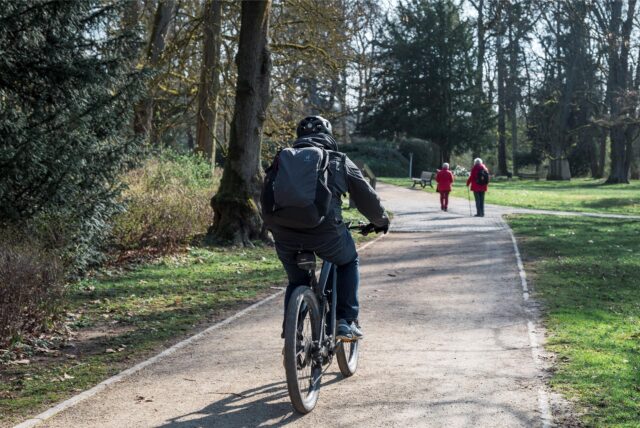 Ein Radfahrer fährt durch einen Park.