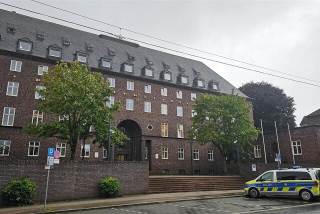 Das Polizeipräsidium Recklinghausen von außen. Auf dem Parkplatz vor dem Gebäude stehen Polizeiautos.