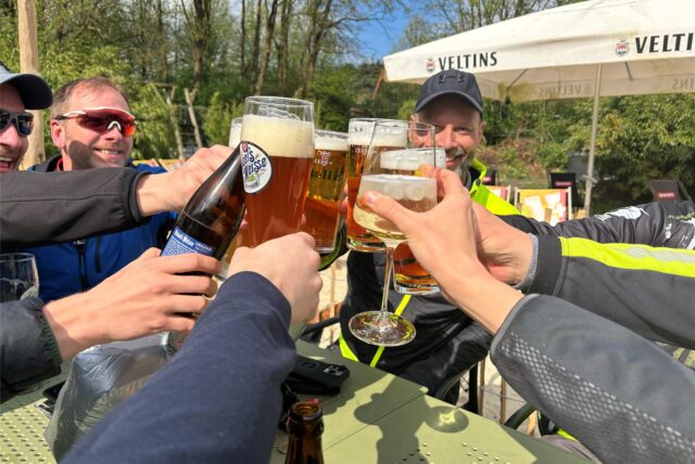 Eine Gruppe von Radfahrern stößt im „Bergmann’s“ Biergarten in Datteln-Ahsen mit Bier und Wein an.