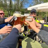 Eine Gruppe von Radfahrern stößt im „Bergmann’s“ Biergarten in Datteln-Ahsen mit Bier und Wein an.