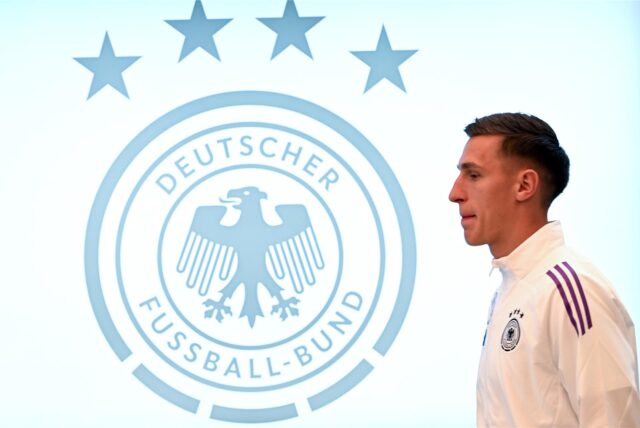 Nico Schlotterbeck steht neben dem DFB-Logo.