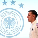 Nico Schlotterbeck steht neben dem DFB-Logo.