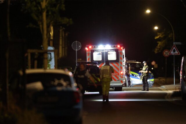 Spezialkräfte der Polizei stehen während eines Einsatzes an der Netteberger Straße in Selm neben einem Rettungswagen.