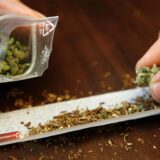 Ein Tütchen mit Cannabis wird auf ein Papier zum Drehen eines Joints geschüttet. (Symbolbild)