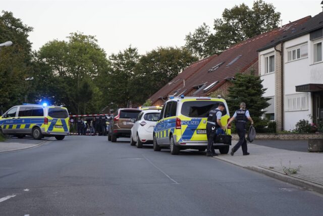 Polizeiautos und Polizeibeamte stehen auf einer Straße in Recklinghausen. Im Hintergrund ist Absperr-Flatterband zu sehen.