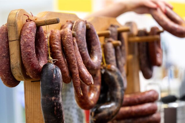 Symbolfoto von verschiedenen Wurstsorten, die an einem Stand aufgestellt sind