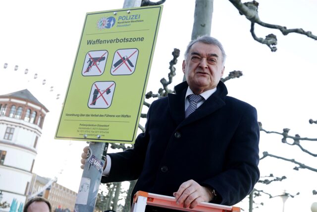 NRW-Innenminister Herbert Reul (CDU) an der Düsseldorfer Rheinufer-Promenade mit dem Schild zur Waffenverbotszone. Auch in Köln gibt es vergleichbare Schilder. Und bald auch in Castrop-Rauxel?