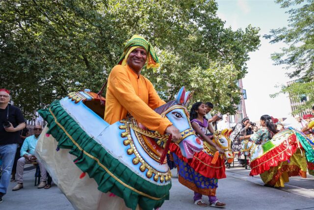 Tänzer in farbenfroher Kleidung beim tamilischen Sommerfest.