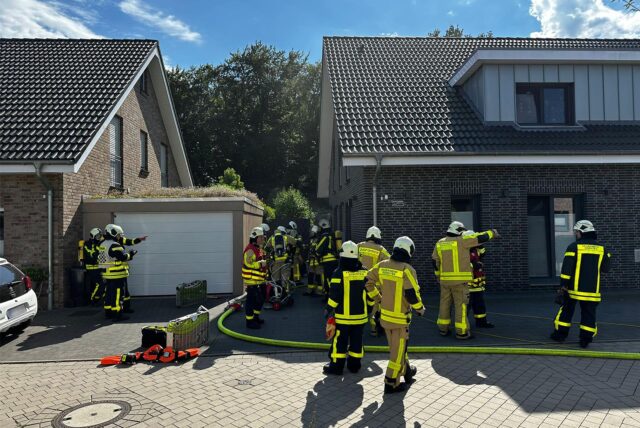 Mehrere Feuerwehrleute stehen vor einem Einfamilienhaus in Dorsten.