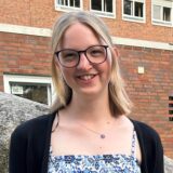 Marieke Petek steht vor dem Eingang des Willy-Brandt-Gymnasiums in Oer-Erkenschwick.