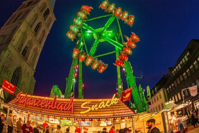 Besucher fahren in Hamm bei der Kirmes Stunikenmarkt mit einem Fahrgeschäft.