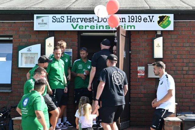 Menschen stehen vor dem Vereinsheim des SuS Hervest-Dorsten.