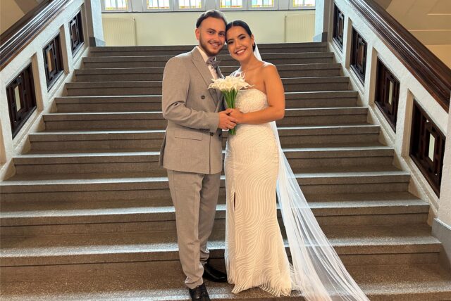 Das Brautpaar Elif und Faruk Varol steht auf der Treppe im Rathaus.