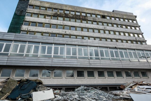Ein siebenstöckiges, leerstehendes Gebäude in Recklinghausen. Im Vordergrund liegt Bauschutt und Gerümpel.