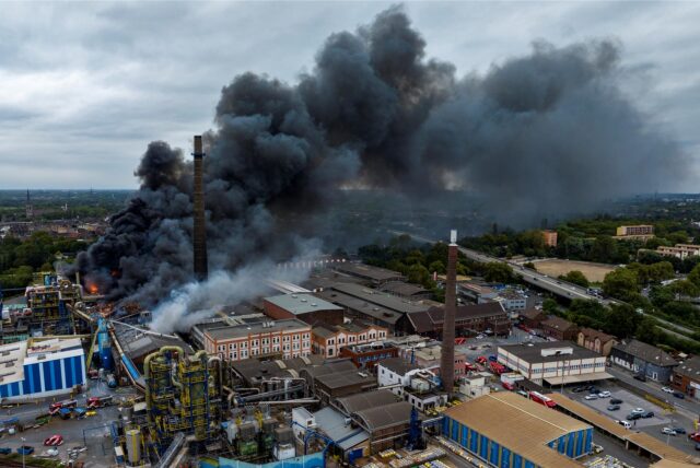 Dichter Rauch steigt bei einem Brand aus einem Chemiewerk auf. Wegen eines Brandes mit starker Rauchentwicklung in einem Duisburger Chemieunternehmen hat die Stadt die Bevölkerung aufgefordert, zu Hause zu bleiben und Fenster und Türen zu schließen.